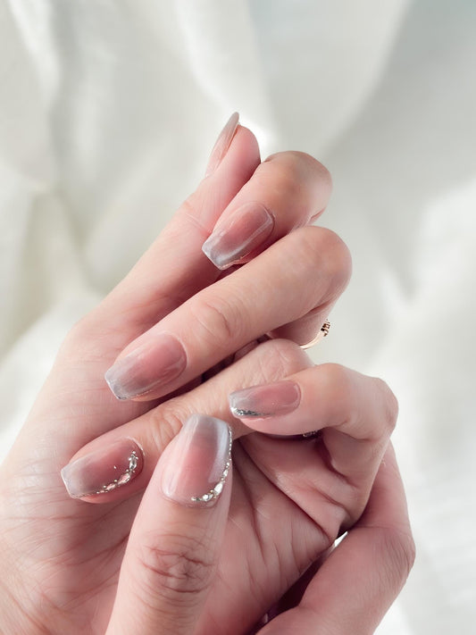 Hand with Square shape pink ombré press-on nails with silver cat-eye shimmer and rhinestone accents