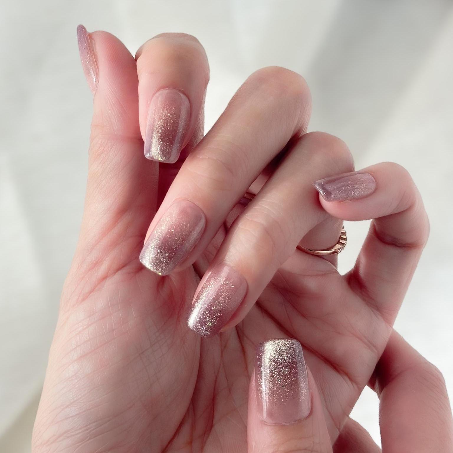 Hand with Short square pink mauve ombré press-on nails with fine glitter shimmer, soft blush gradient, and glossy finish