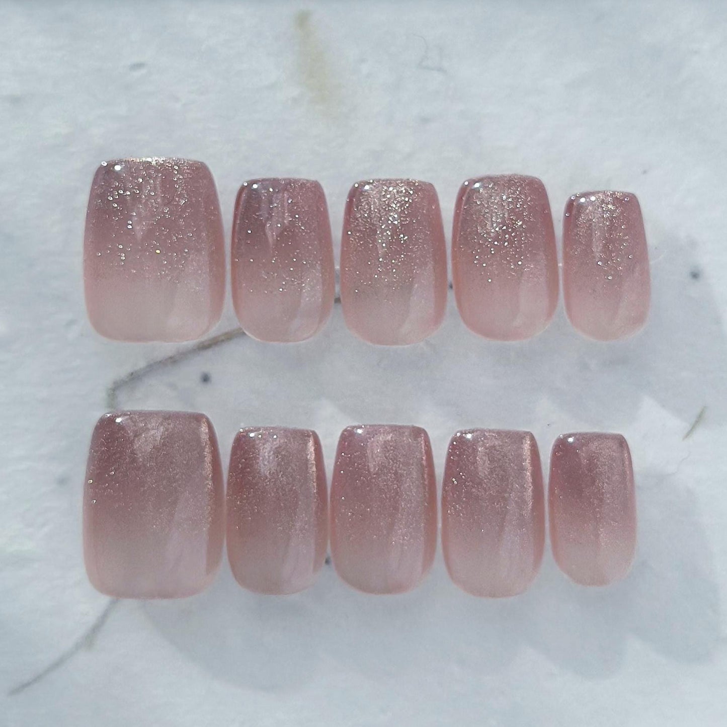 Short square pink mauve ombré press-on nails with fine glitter shimmer, soft blush gradient, and glossy finish