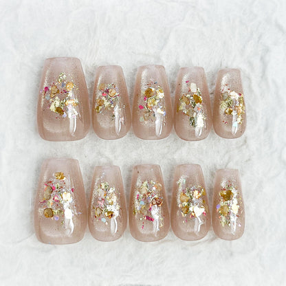 Press on nail with nude base and crushed foil glitter accent in gold, artificial nails