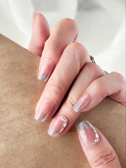 Hand with Square shape pink ombré press-on nails with silver cat-eye shimmer and rhinestone accents