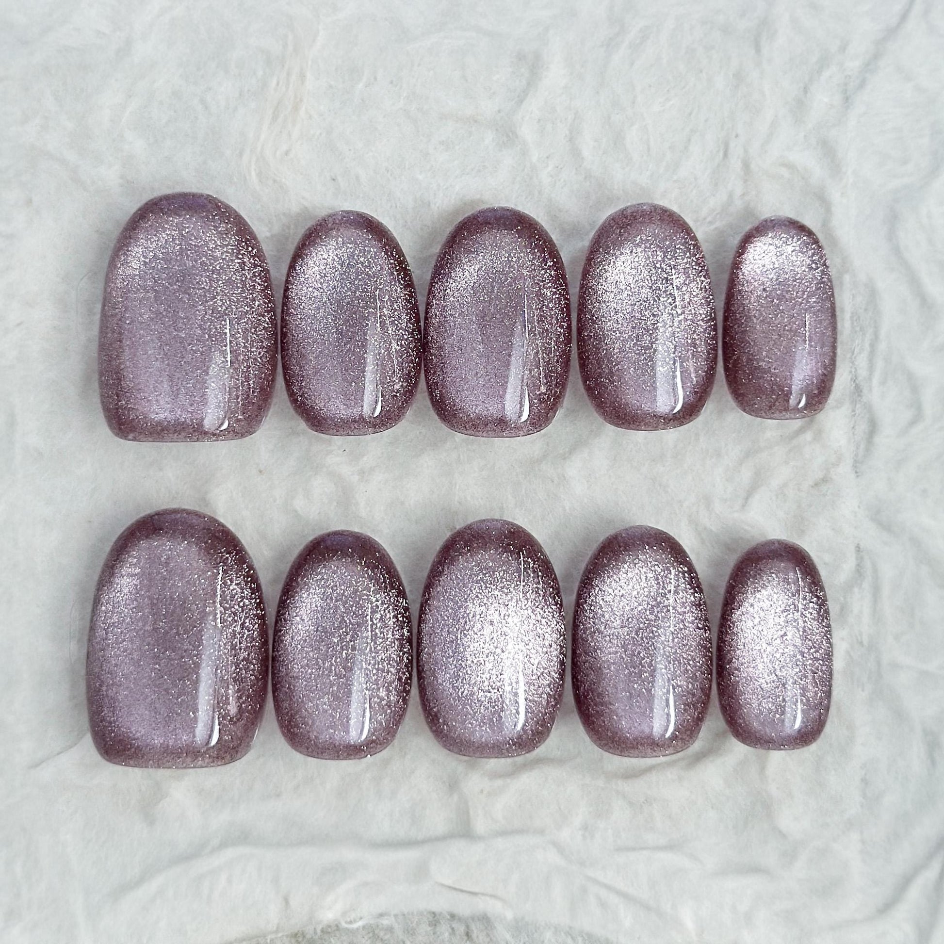 Short oval press-on nails in a metallic mauve cat-eye shimmer, glossy finish, luxury reusable press-on manicure by ManiFleur
